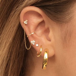 Close-up of gold flower tassel ear chain with sparkling zircons and cuff earrings set