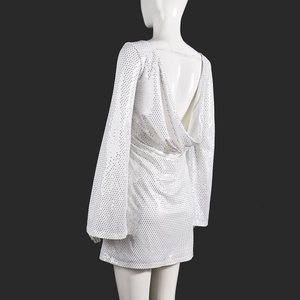 Détail de la robe mini à paillettes blanches avec dos nu et longues manches évasées