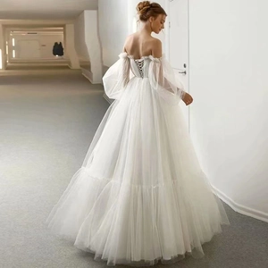 Elegant white off-shoulder bridal gown with sheer puff sleeves and lace-up back detail