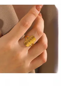 Detailed view of rectangular gold ring with engraved moon and stars on female hand