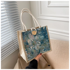 Detail of linen handbag with teal botanical patterns and rustic wooden button closure