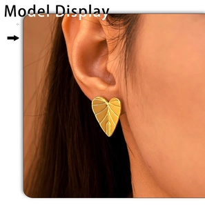 Close-up of heart-shaped leaf vein stud earring in gold plating worn by model