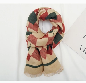 Detail of red and green diamond knit scarf with textured tassels on white background
