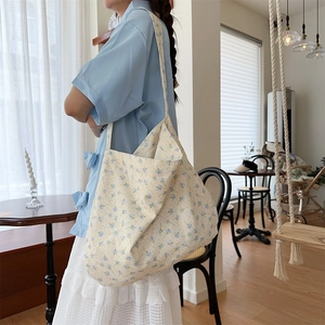 Detail shot of a large floral canvas tote bag showing the blue flower pattern and texture