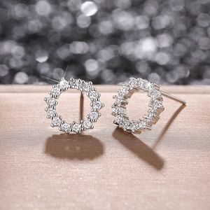 Macro shot of silver circular wreath earrings with sparkling zircons and fine textures