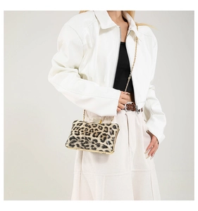 Detail of a leopard print hard shell evening bag with gold frame and chain strap