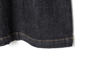Détail de l'ourlet en denim bleu foncé avec des coutures contrastées orange professionnelles