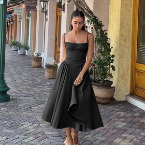 Elegant black mid-length strap dress with cinched waist and French vintage style on street