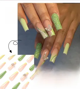 Detail of long coffin nails with green glitter, French tips, and 3D silver butterflies