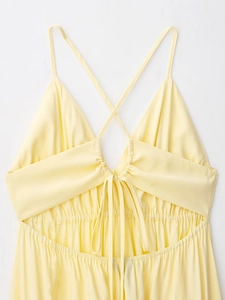 Détail du dos d'une robe d'été jaune avec bretelles croisées et nœud papillon élégant
