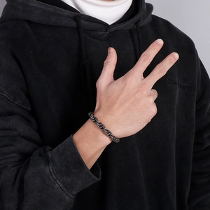 Close-up of chunky dark gray punk style stainless steel chain bracelet on model wrist