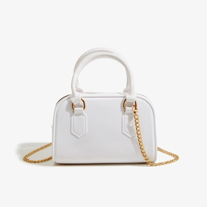 Vue détaillée du sac Boston en PVC blanc brillant avec bandoulière en chaîne dorée