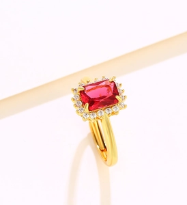 Macro shot of gold-plated ring with red rectangular stone and white crystals