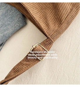 Detailed shot of brown corduroy bag strap with adjustable golden metal hardware buckle