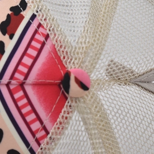 Macro view of leopard print baseball cap with pink stitching and breathable mesh detail