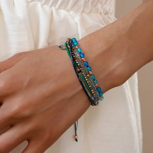 Detail van gelaagde boho kralenarmbanden met blauwe agaat kralen en verstelbaar koord