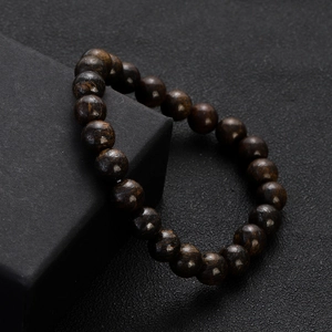 Close-up of deep brown wooden round beads bracelet on a black textured jewelry gift box