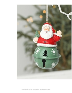 Detail of Santa Claus ornament with green metal bell hanging on a Christmas tree
