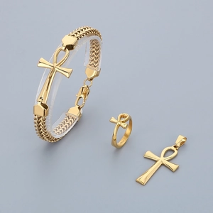 Detail of gold Ankh jewelry set featuring a necklace, ring and bracelet on a grey background