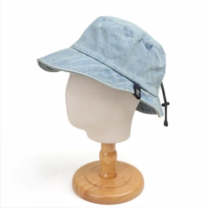 Detail view of adjustable drawstring and texture on light blue denim bucket hat