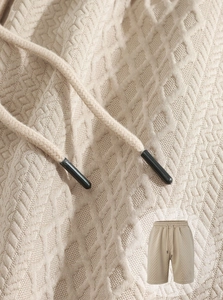 Macro shot of beige jacquard knit texture on casual shorts with drawstring waist