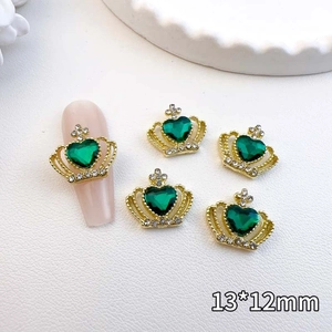 Detail of 13x12mm gold crown nail art charm with green heart gem and rhinestones