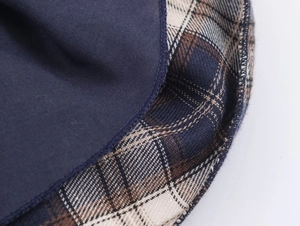Detailed macro view of dark blue fabric and brown-white plaid stitching texture