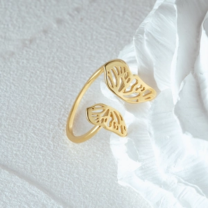 Macro shot of gold hollow butterfly wing ring on white floral background detail