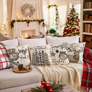 Close-up of four festive Christmas decorative pillows with holiday prints in a cozy room
