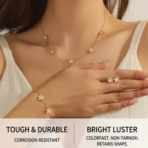 Detail shot of woman wearing gold five-petal flower necklace, earrings, and bracelet set