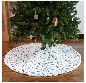 Macro view of white plush Christmas tree skirt with decorative gold foil feather patterns