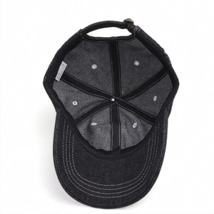 Detailed interior of washed black denim baseball cap with reinforced seams and metal buckle