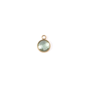 Close-up of a 7mm round faceted green birthstone charm with gold-plated bezel setting