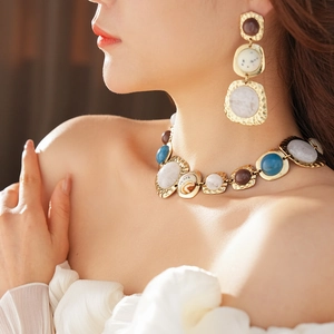 Close-up of vintage irregular geometric jewelry set with resin stones on a model