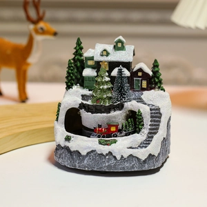 Detailed view of resin Christmas snow house with a red miniature train and LED lighting
