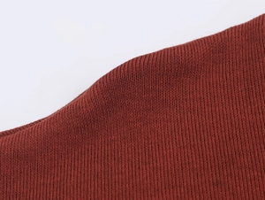 Vue macro de la texture du tricot rouge foncé et des coutures fines de l'ensemble jupe