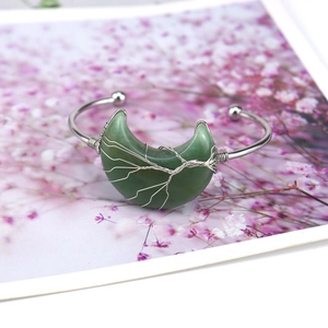 Macro detail of silver wire wrapped tree of life on green moonstone bangle bracelet