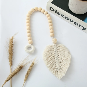 Detail of bohemian woven cotton leaf and natural wood beads curtain tieback decoration