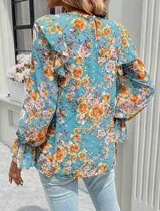 Rear view detail of long sleeve blue blouse with orange floral prints and elegant fit