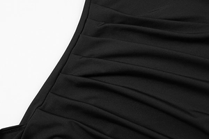 Close-up of black ruched fabric texture with elegant side pleats on the evening dress