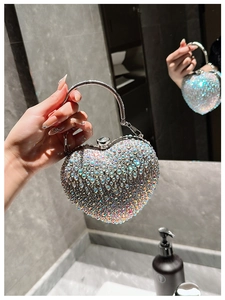 Detail of heart-shaped evening bag with iridescent rhinestones and silver handle