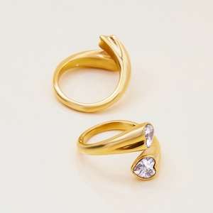 Macro shot of two gold heart zircon rings featuring polished finish and sparkling gems