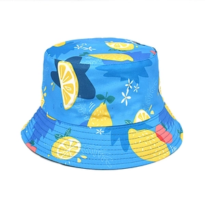 Detail of blue bucket hat featuring vibrant summer lemon print and white floral patterns