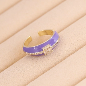 Dettaglio anello dorato smalto viola con zircone su vassoio portagioie in beige