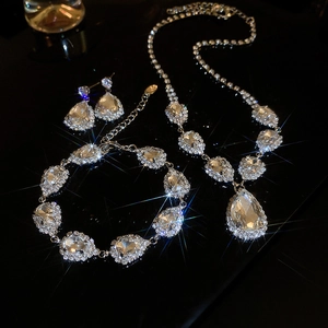 Detailed set of silver rhinestone jewelry with teardrop crystals and starburst shimmer