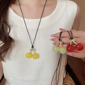 Detailed close-up of colorful cherry pendants with wax cord chain on a model