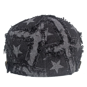 Détail d'un béret en denim vieilli avec motifs d'étoiles et bords effilochés rétro