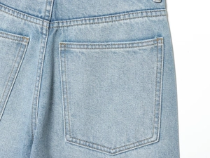 Dettaglio della tasca posteriore e cuciture di alta qualità su jeans in denim azzurro