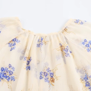 Dettaglio del girocollo a pieghe di una camicetta in chiffon a fiori da donna