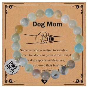 Gros plan de perles en pierre zébrée et breloque Dog Mom sur carte cadeau festive